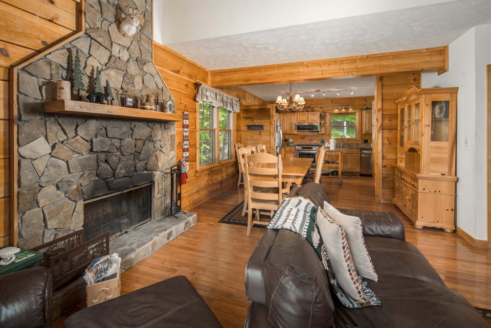 Open living and dining area centered around the wood-burning stone fireplace