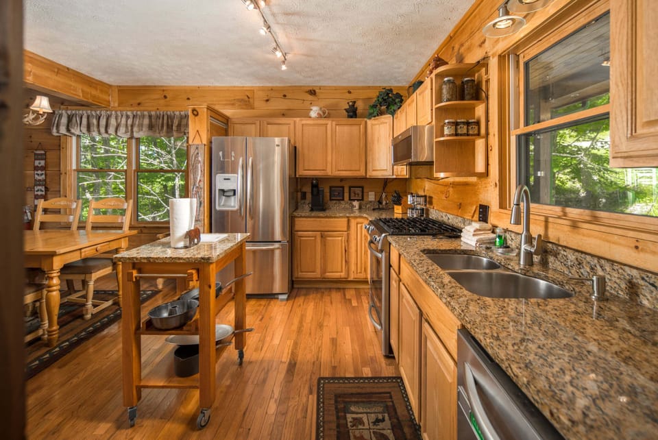 Fully equipped kitchen with granite countertops, stainless steel appliances, and a breakfast bar