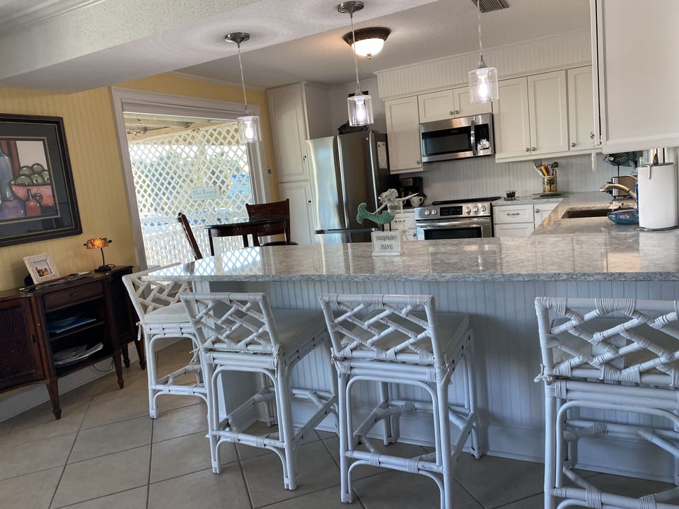 New kitchen with designer cabinets, quartz countertop, appliances and barstools