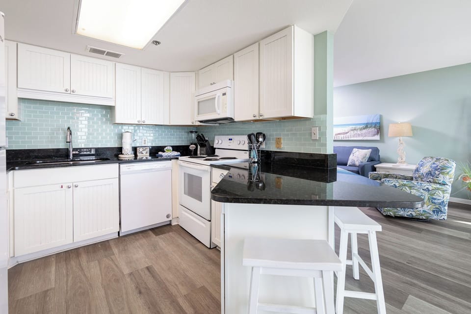 Prepare meals in the stylish kitchen featuring sleek countertops and a breakfast bar