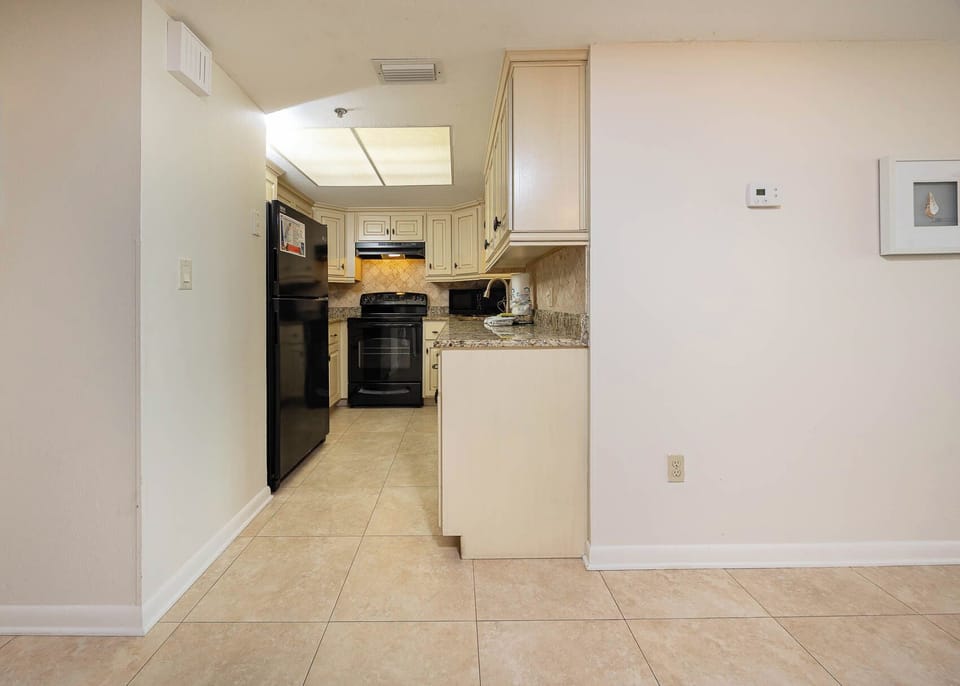 This kitchen features granite countertops, black appliances, and a convenient layout for meal preparation