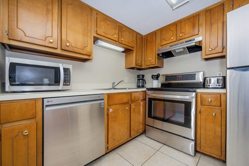 The kitchen features wood cabinetry, stainless appliances, and a convenient layout for preparing meals during your stay