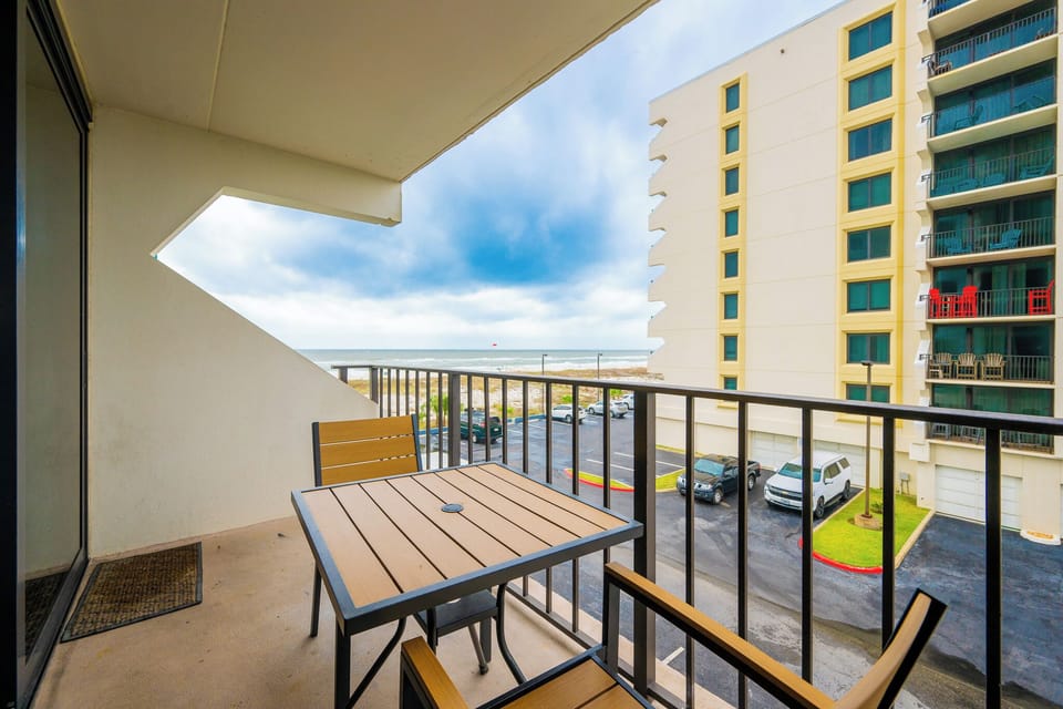 Enjoy a relaxing moment on the balcony with a view of the beach, perfect for unwinding after a day of adventure