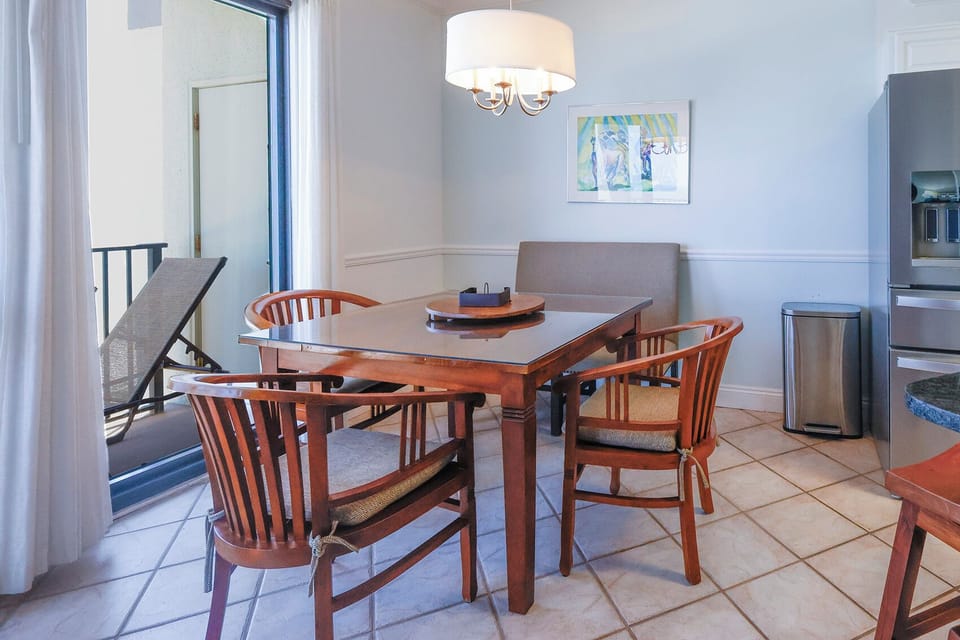Bright dining area features a wooden table with seating, leading to a balcony for enjoying the fresh air and views