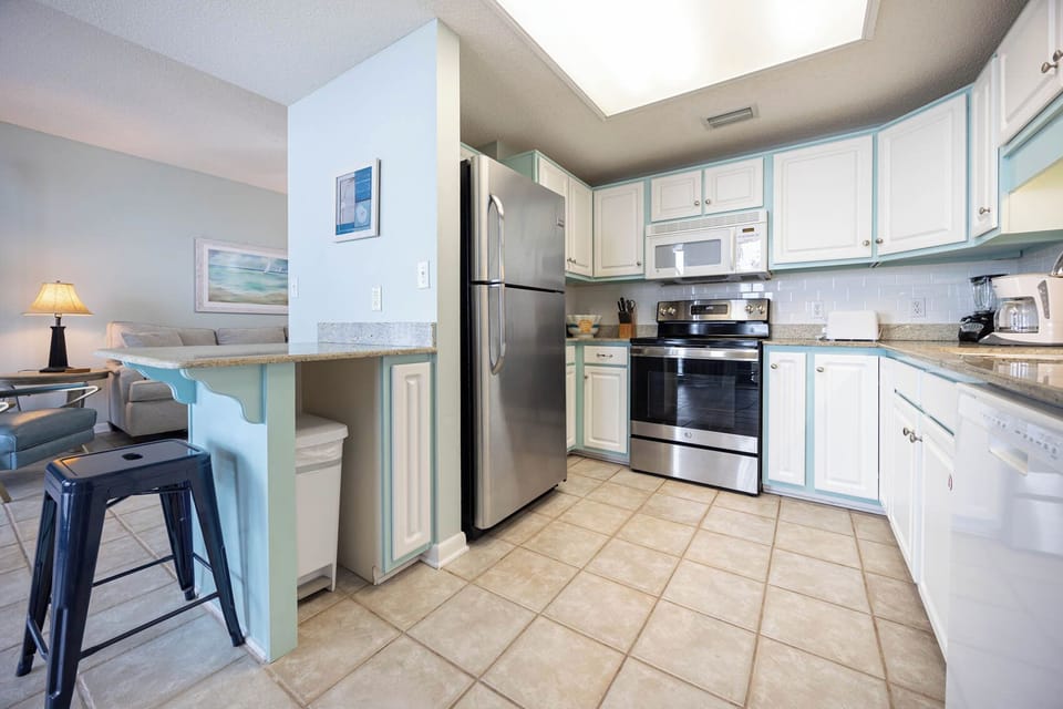 Prepare meals with ease in this inviting kitchen featuring stainless steel appliances and a convenient breakfast bar