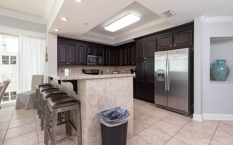 Gather around the breakfast bar with stylish seating and enjoy the inviting atmosphere of this stylish kitchen