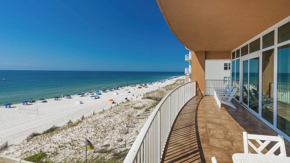 Breathe in the fresh air while relaxing on the spacious balcony with seating and views of the expansive coastline