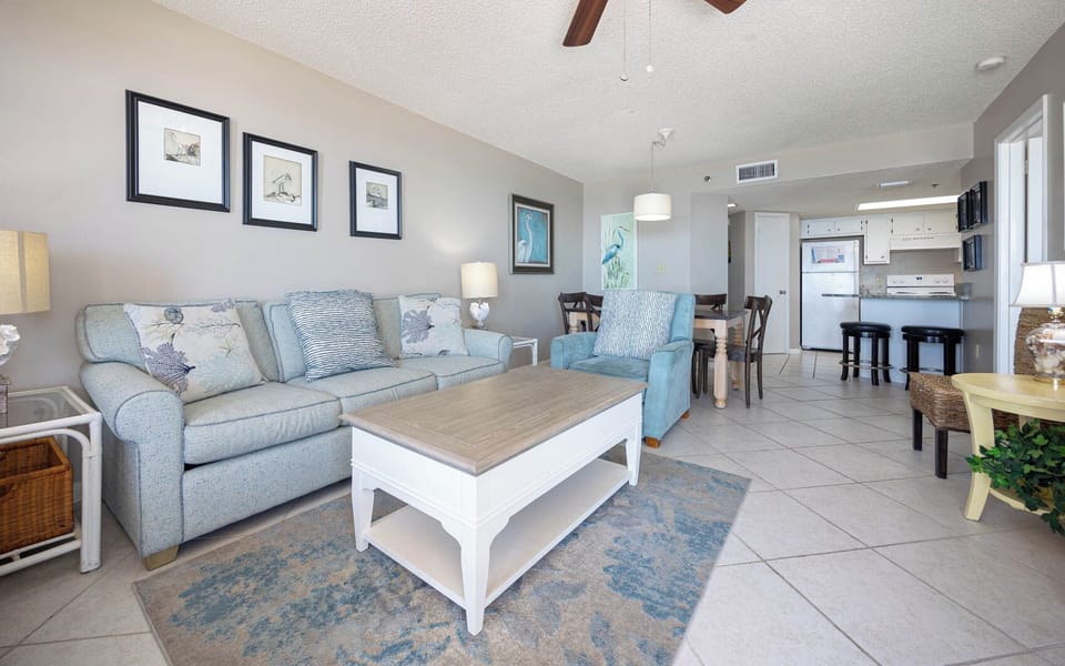Spacious living area with a cozy queen sofa sleeper, coastal decor, and a seamless flow to the dining space