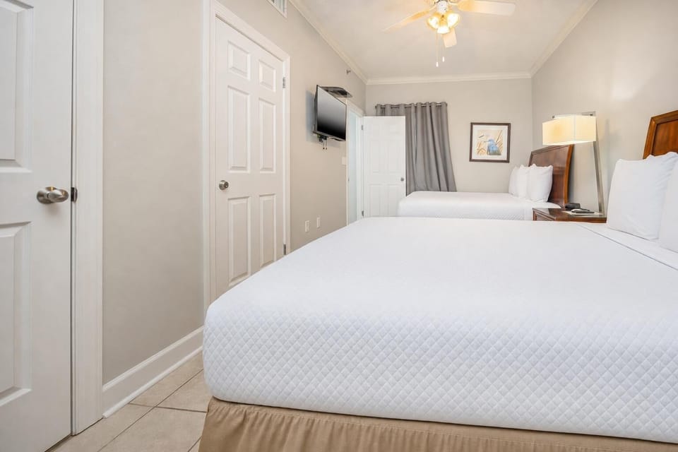 Rest peacefully in this cozy guest bedroom, where soft queen beds invite dreams of sunlit beach days ahead
