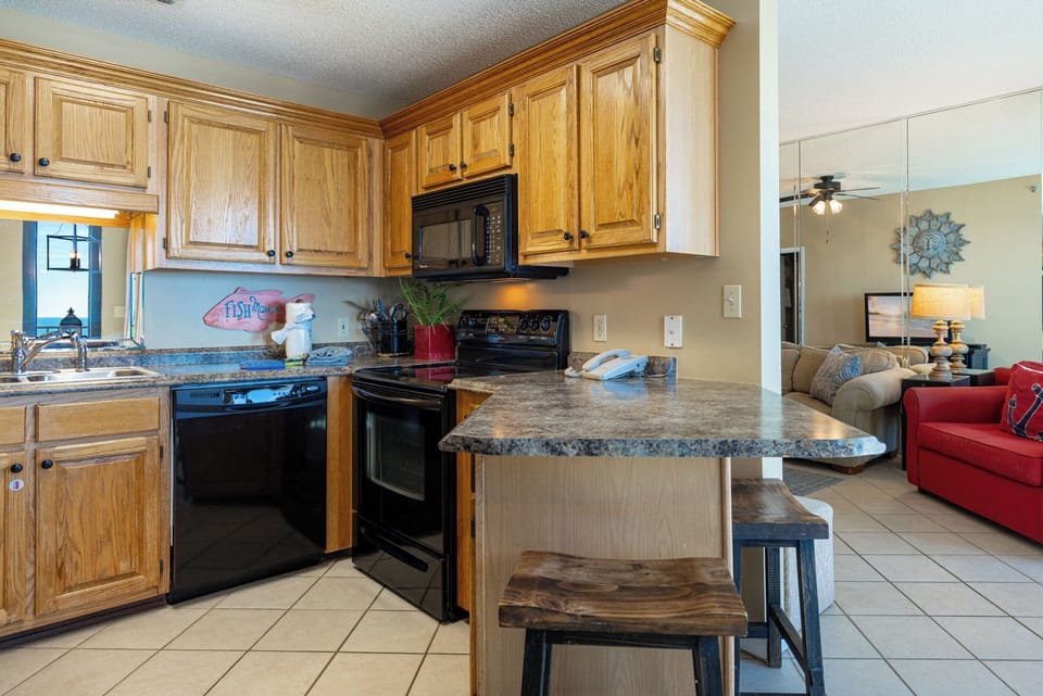 Prepare meals in this inviting kitchen with wooden cabinets and a breakfast bar, perfect for family meals