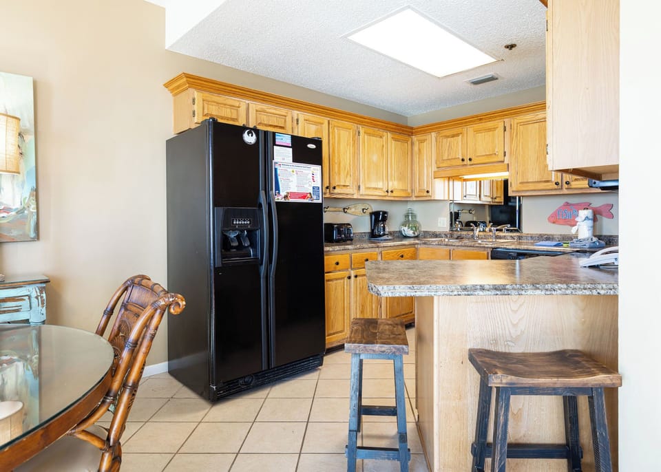Cook and gather at this inviting kitchen with wooden cabinets, a breakfast bar, and a dining table