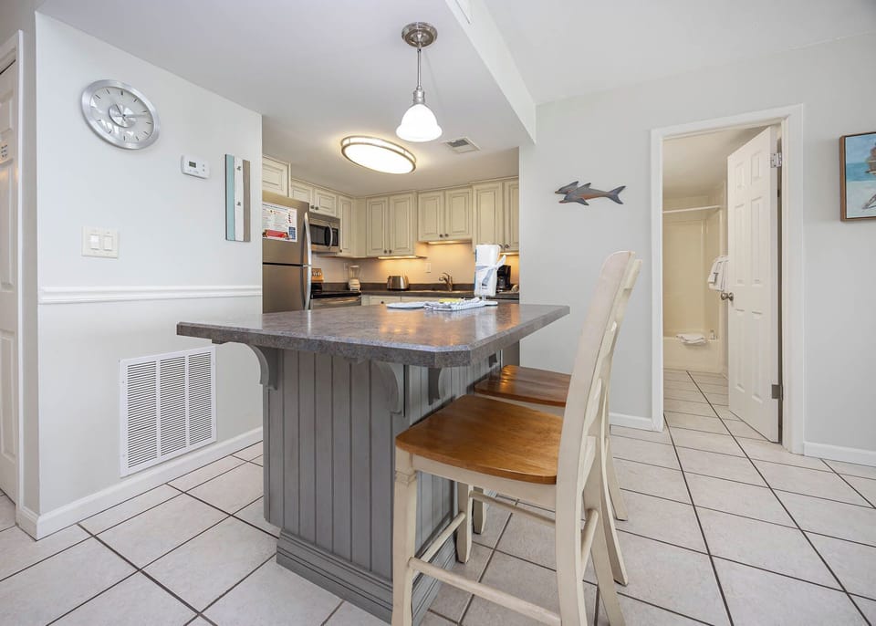 This kitchen features light cabinetry, stainless appliances, and a breakfast bar, perfect for casual dining and entertaining