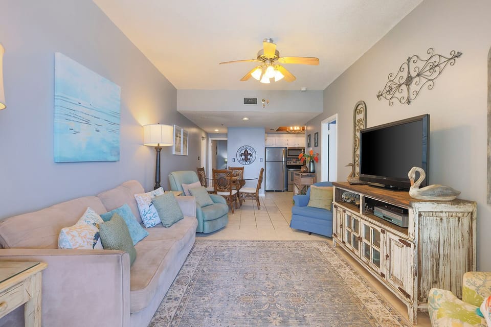 The living area features a comfortable sofa, a large TV, and a dining space, perfect for relaxation and gatherings