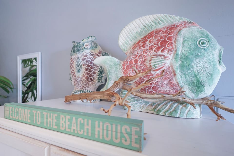 This charming decor features colorful fish sculptures and a welcoming sign, perfect for a beach-themed getaway