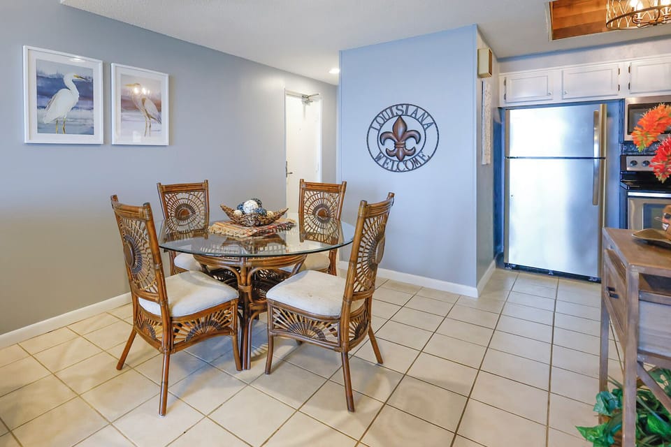 This dining area features a glass-top table surrounded by stylish wicker chairs, perfect for enjoying meals together