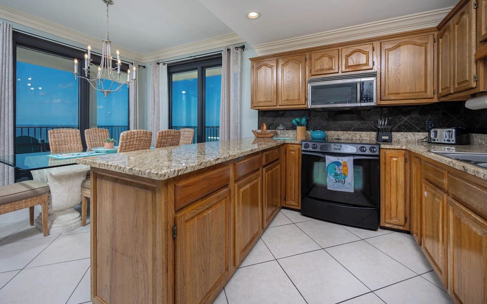 Prepare meals in the spacious kitchen with a breakfast bar, while enjoying beach views from the balcony
