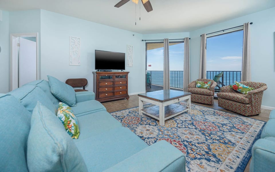 Brightly colored chairs complement the light blue walls in this inviting living area with a view of the beach