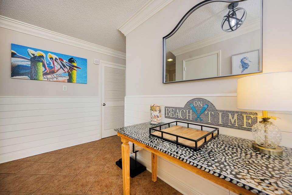 Step into this inviting entryway, where coastal artwork and charming decor welcome you to your beach getaway