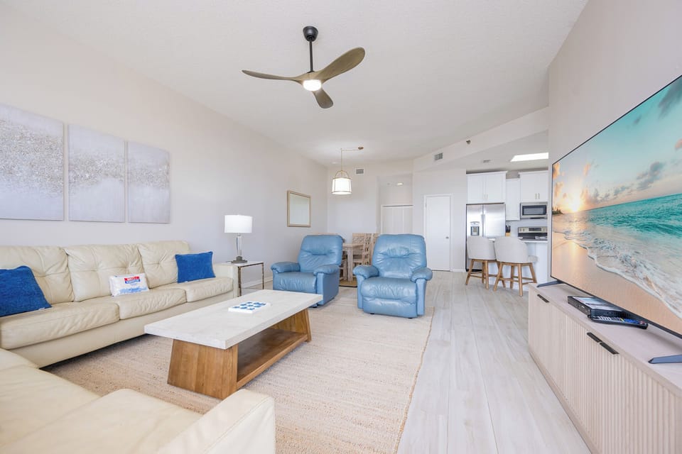 Two plush blue recliners in the living room offer a perfect spot to unwind and watch a sunset by the gulf coast on TV