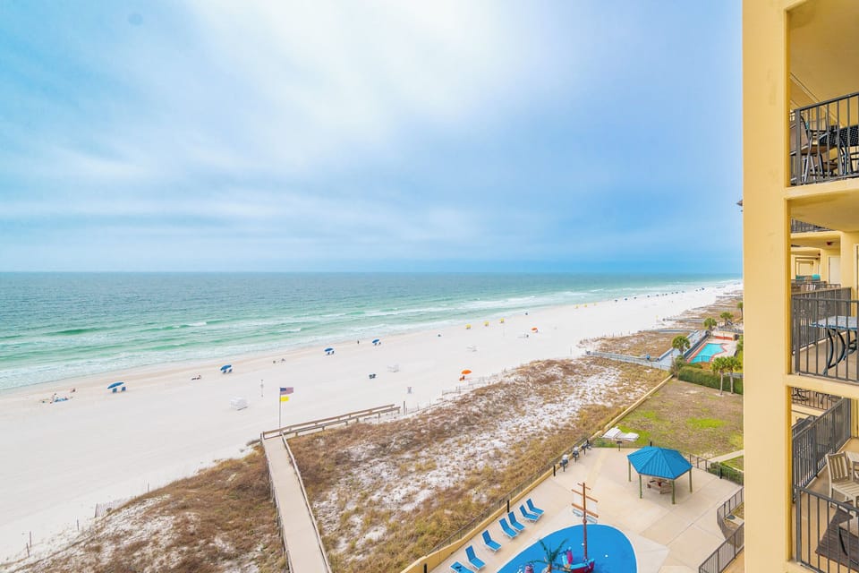 Cool salt air fills your lungs as you stroll down the wooden path to the soft white beach below