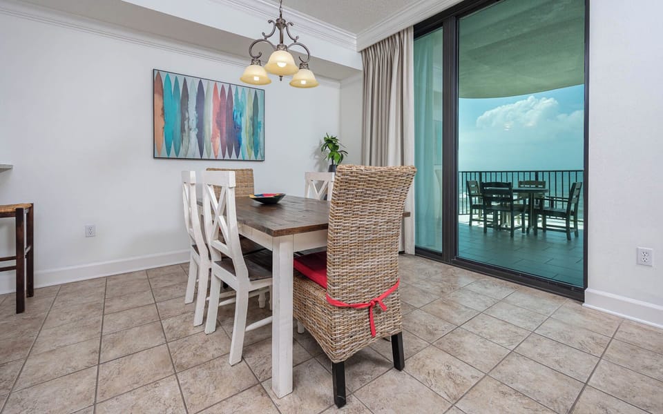 Gather around the rustic dining table, with stylish chairs and a view of the inviting outdoor space