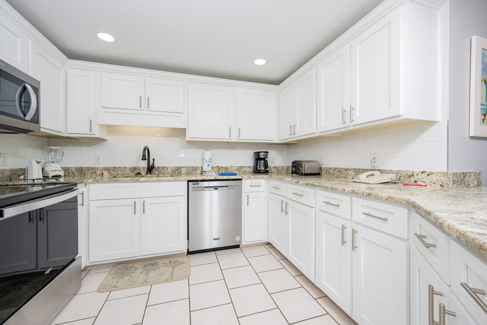 Prepare meals in the sleek kitchen featuring granite countertops, stainless appliances, and ample storage space