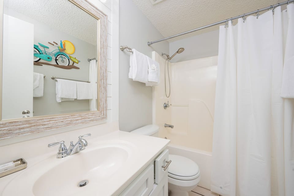 Refresh in this clean guest bathroom featuring a spacious vanity, fluffy towels, and a charming bicycle decor accent