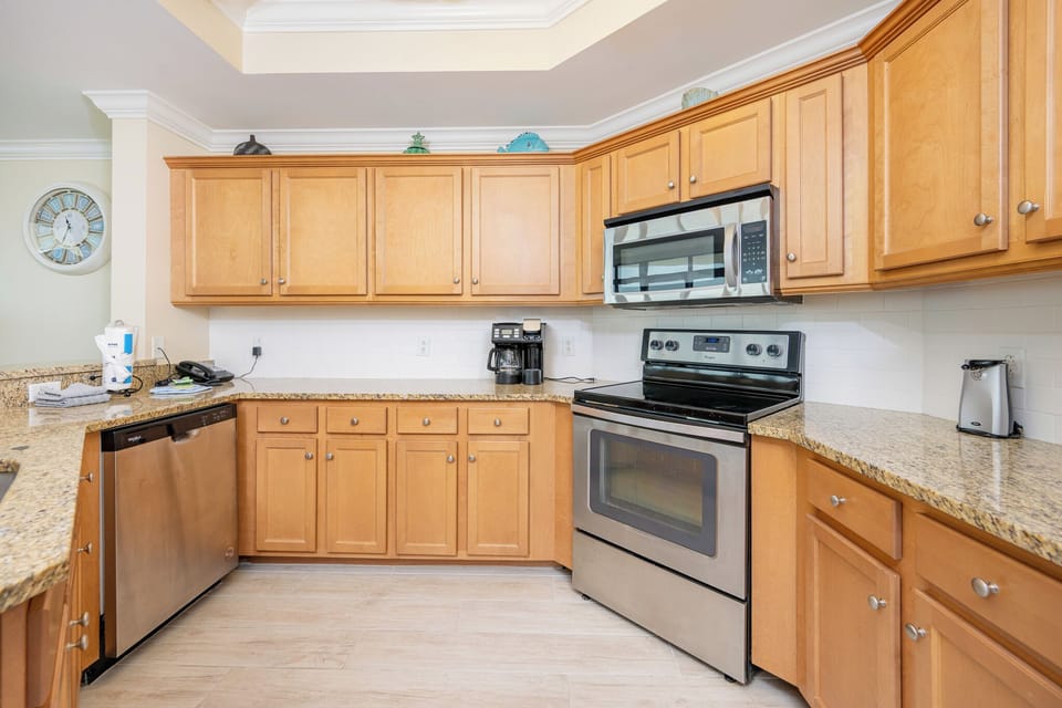 Kitchen featuring stainless appliances, granite countertops, and a coffee station, perfect for preparing meals