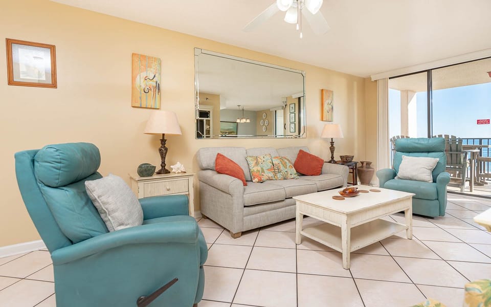 Relax in the inviting living area featuring a sofa with queen sleeper, vibrant decor, and a beach view