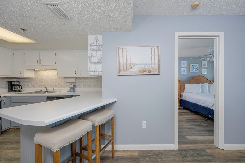 Soft blue walls soothe as you move from the kitchen's breakfast bar into the queen guest suite's cozy calm