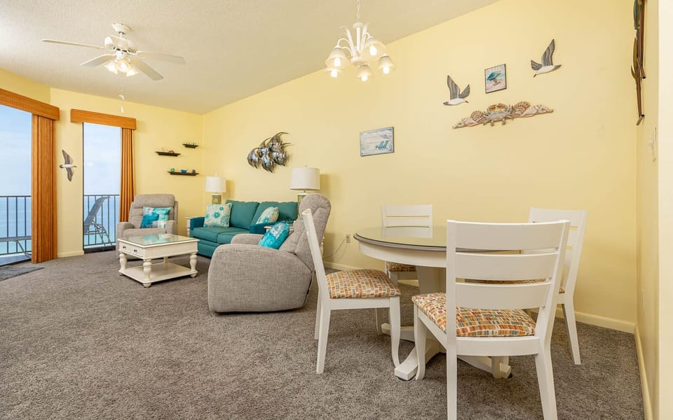 Living area features a turquoise sofa with queen sleeper, cozy chairs, and a dining table, creating a cheerful vibe