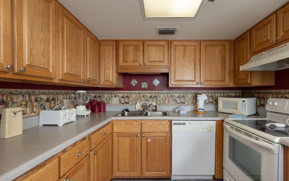 Inviting kitchen featuring wooden cabinetry, essential appliances, and a cozy atmosphere for cooking