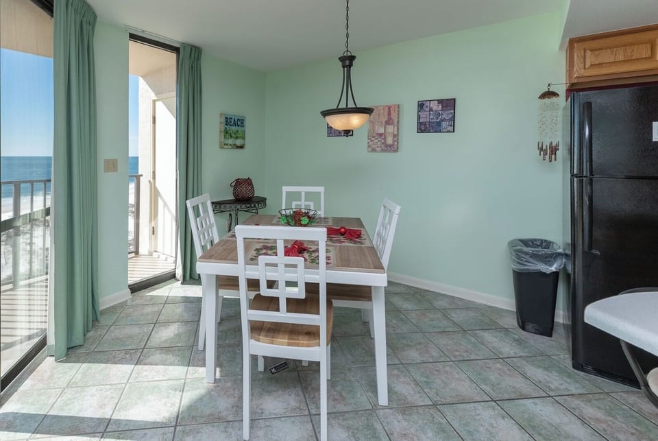 Enjoy meals at this dining area, featuring a wooden table, bright decor, and a view that invites the outdoors in