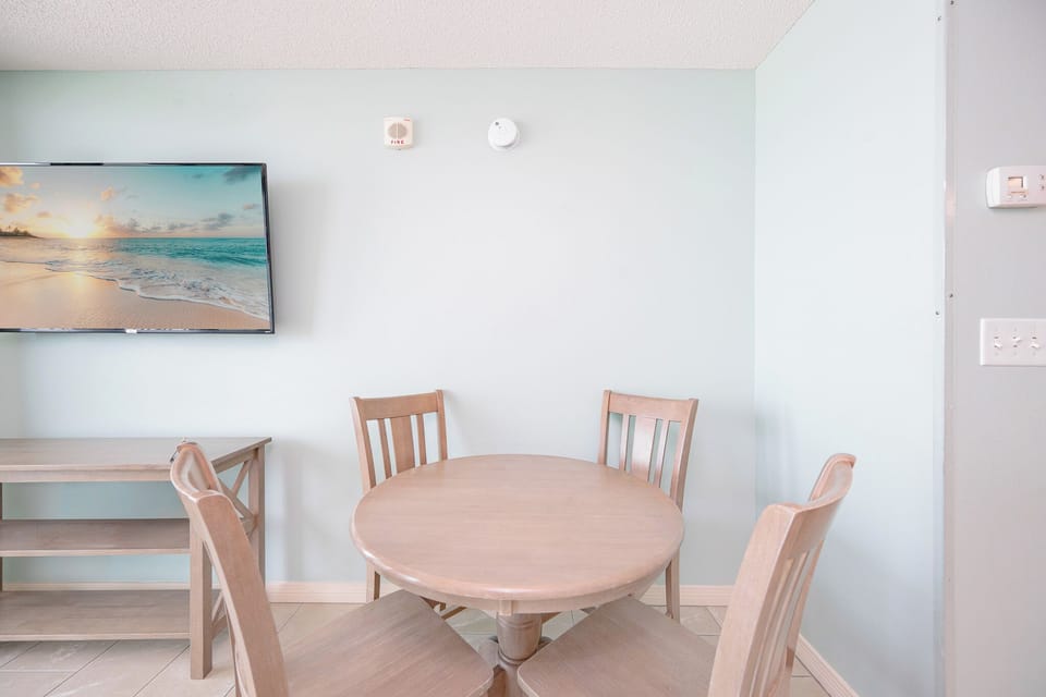 Enjoy meals at the round dining table while taking in views through the expansive glass doors