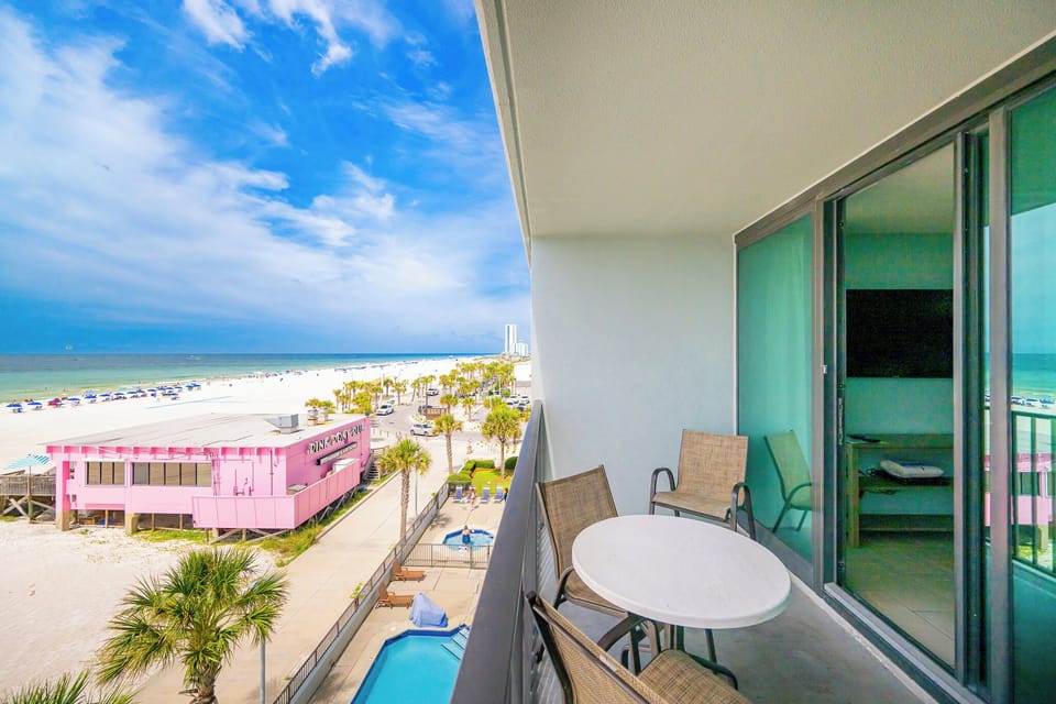 Savor your morning coffee on the balcony with a table and chairs, enjoying views of the tranquil water and beach