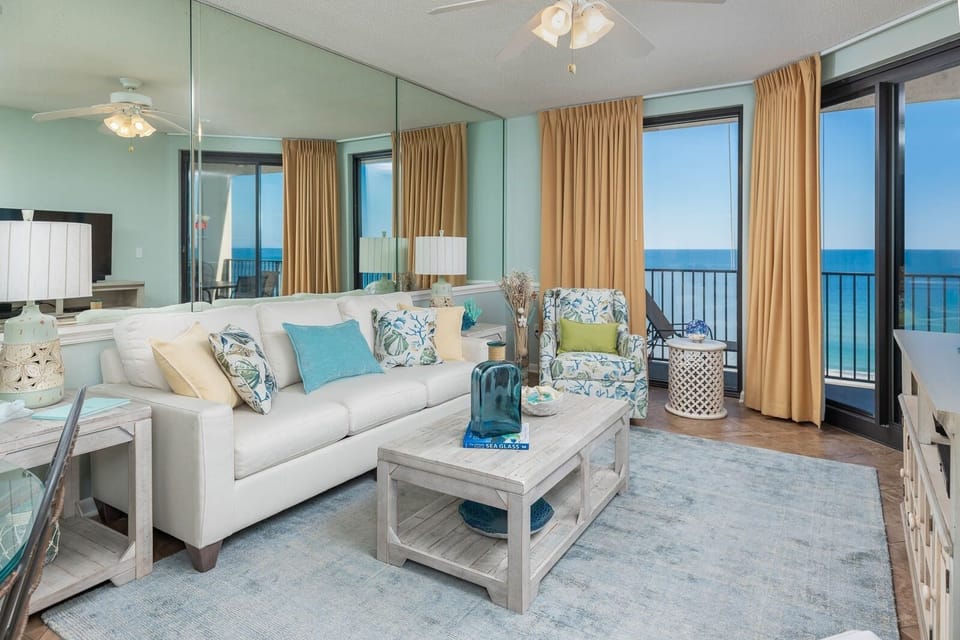 Relax in the inviting living area, featuring a plush sofa with queen sleeper, vibrant decor, and beachfront views