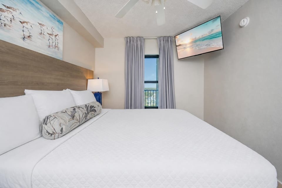 Fluffy pillows invite you to relax in the king suite for a calm movie night after a fun day at the beach