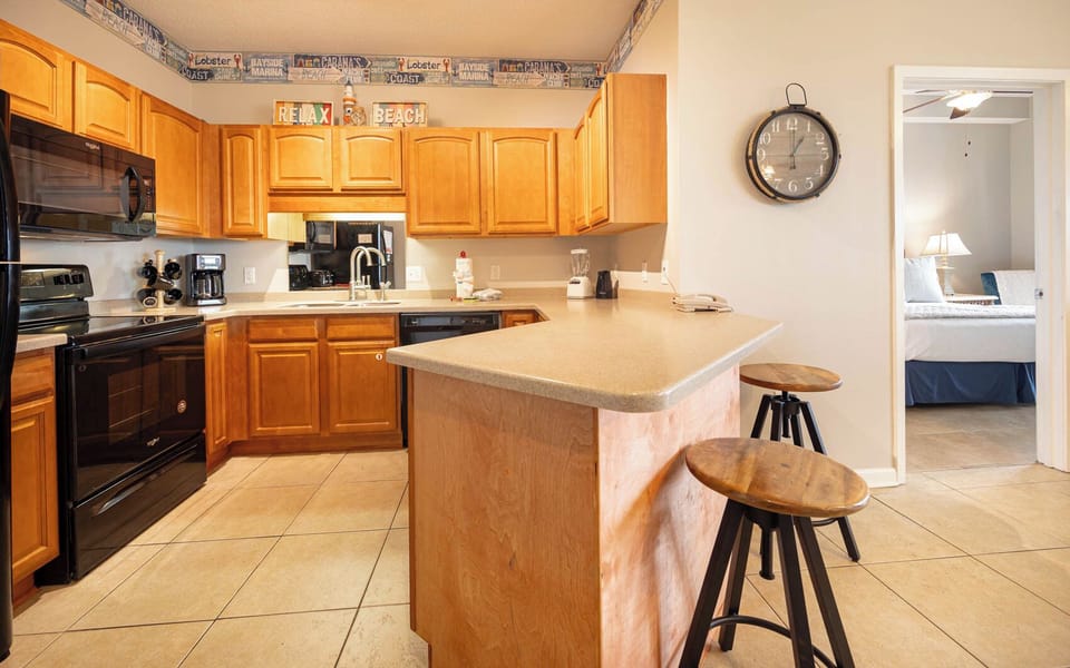 Prepare meals in this stylish kitchen, featuring black appliances and warm wooden cabinetry