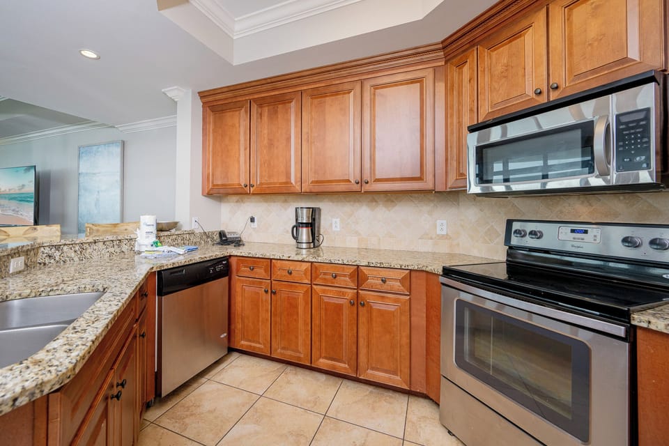 Kitchen featuring warm wood cabinetry, granite countertops, and stainless appliances, perfect for culinary adventures