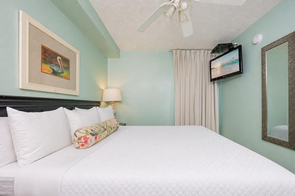 Fluffy pillows invite you to relax in the king suite for a calm movie night after a fun day at the beach