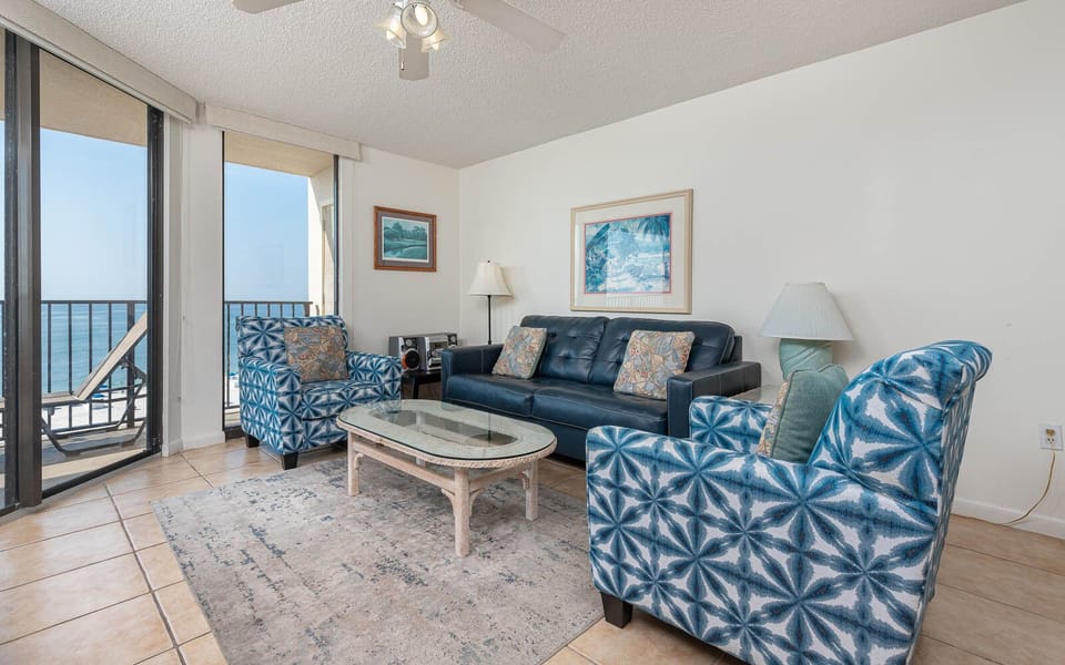 Relax in the inviting living area with comfortable seating, a glass coffee table, and beautiful balcony views