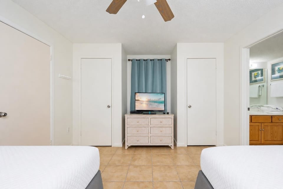 Unwind in this inviting bedroom with two beds, a TV, and easy access to the adjoining bathroom