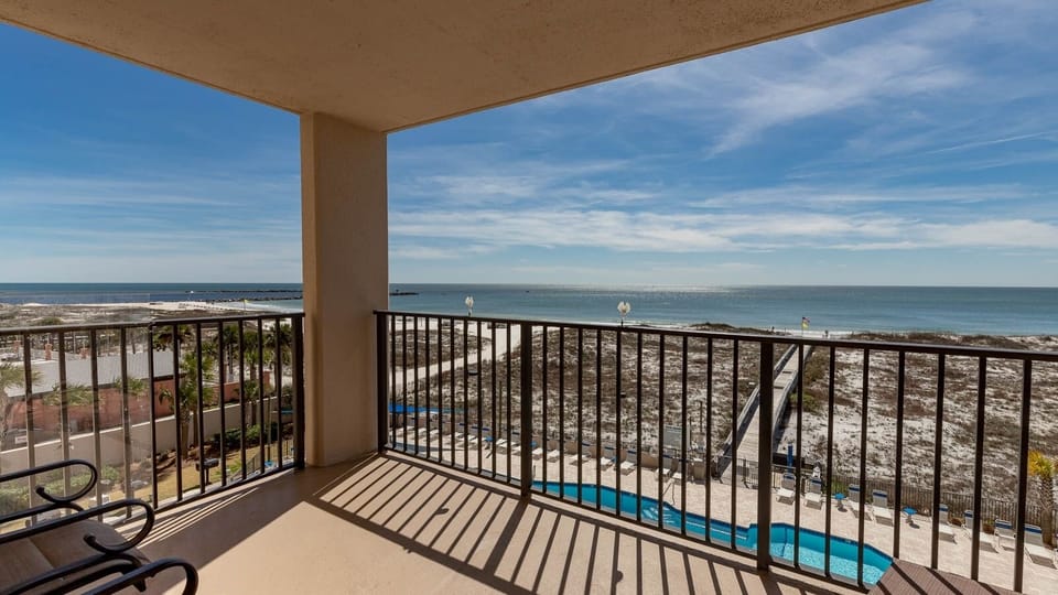Relax on the balcony and enjoy views of the shimmering water and the inviting pool below