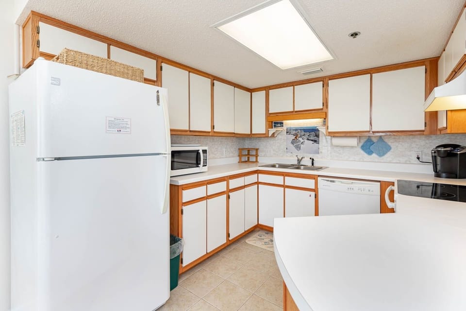 Prepare meals in this bright kitchen featuring ample counter space and white appliances for your convenience