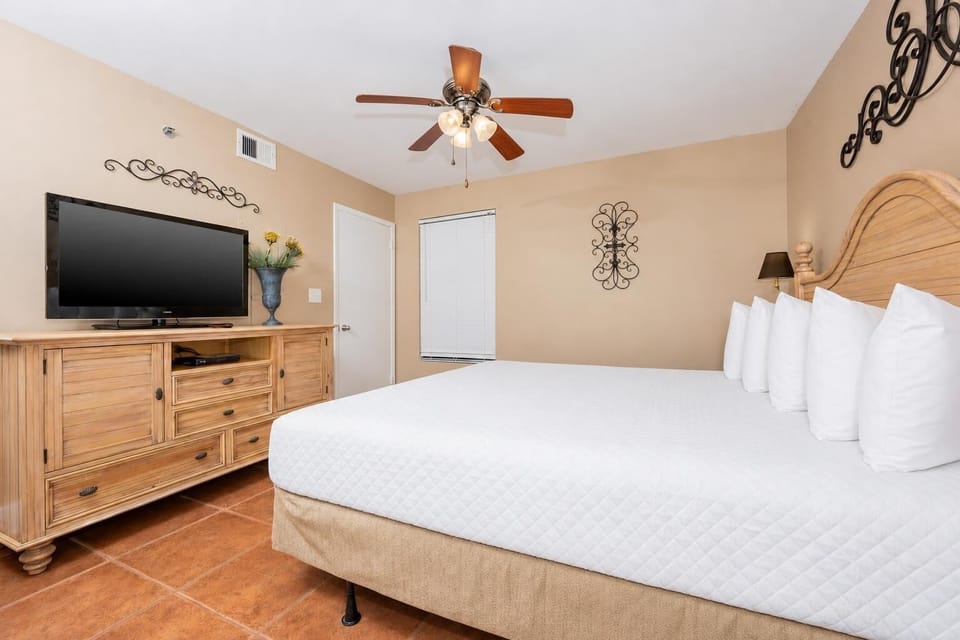 Cozy guest bedroom featuring a king bed, stylish decor, and a flat-screen TV for your relaxation and entertainment
