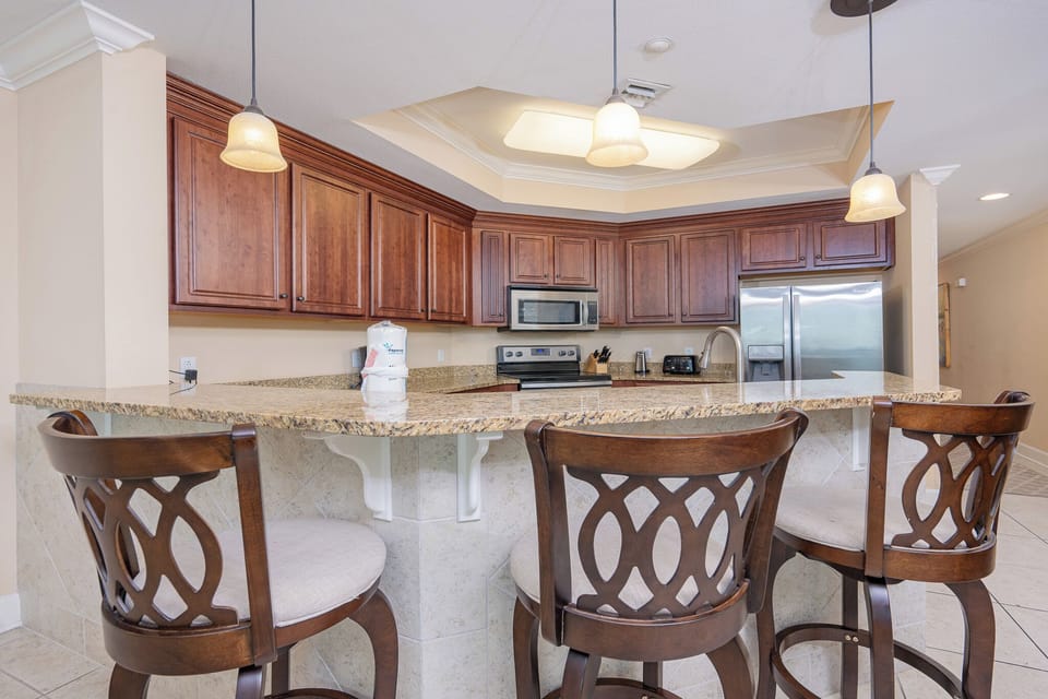 Kitchen features granite countertops, stainless appliances, and stylish bar seating for a cozy gathering