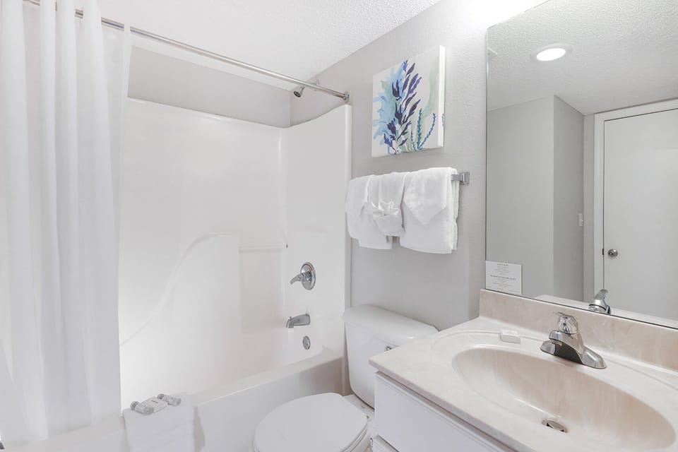 Refresh in this bathroom featuring a tub-shower combo, vanity, and soft towels for your comfort