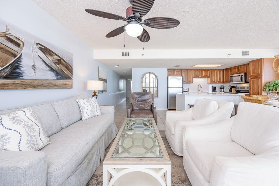 The living room's gentle fan whispers above as you settle into plush chairs for quiet conversation or movie nights