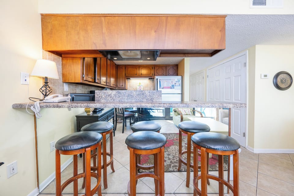 Gather around the sleek counter stools, enjoying casual conversations while gazing at the inviting dining area