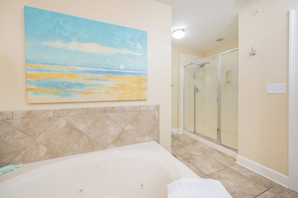 Indulge in a rejuvenating rainfall shower in the master bath, surrounded by calming coastal decor
